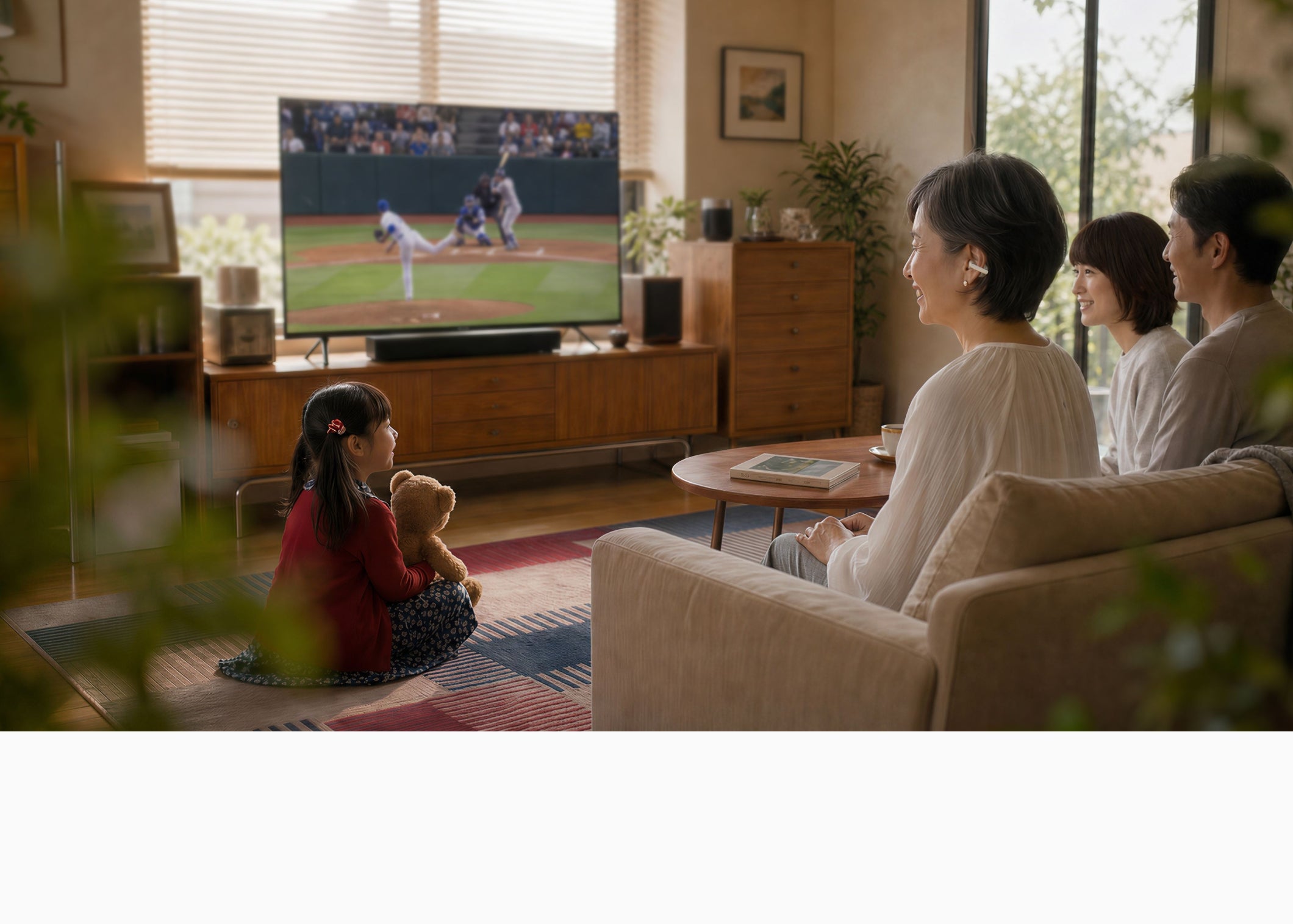 Cearvol集音器でテレビ音声を聞きながら家族でくつろぐリビングシーン