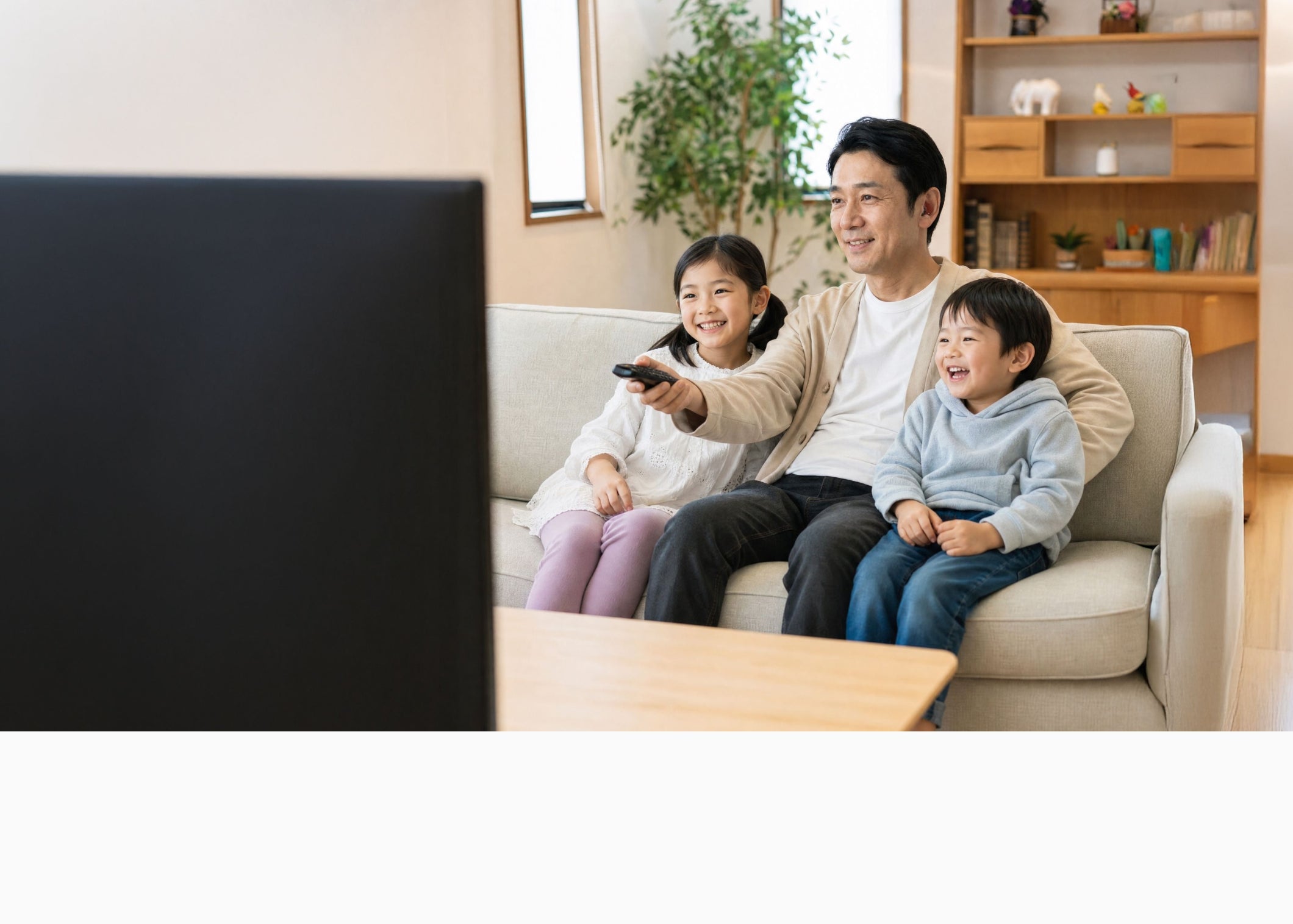 Cearvol（セアボル）の聴覚サポートで家族とリビングでテレビを楽しむ生活シーン画像